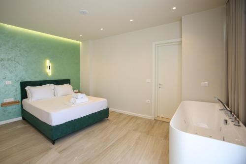a bedroom with a bed and a bath tub at ReiVal Hotel Marina Vlore in Vlorë