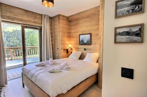 une chambre avec un grand lit et un balcon dans l'établissement Les Chalets C Les Marmottes - NOUVEAU : très beau 4 pièces dont 1 chambre cabine magnifiquement situé au coeur des 3 Vallées MAE-3984, à Méribel