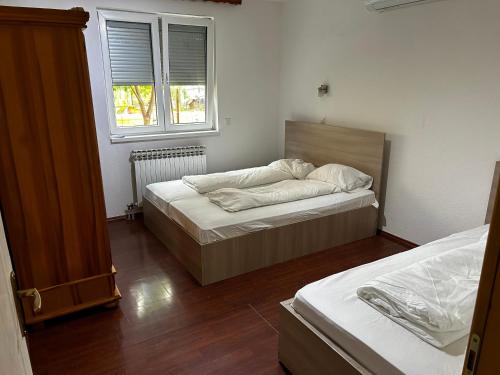 a bedroom with two beds and a window at Ilidza Apartments in Sarajevo