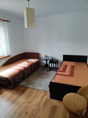 a bedroom with two beds and a table in it at Agroturystyka Mazury u Basi in Łoje