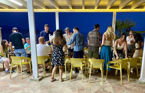 a group of people standing around a table and chairs at Kalemi's Beachside Hotel in Sarandë