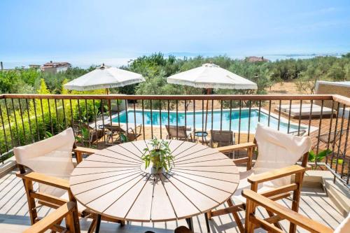 a balcony with a table and chairs and a pool at Petradi Suites in Kalamata