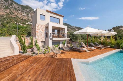 a villa with a swimming pool and a house at Petradi Suites in Kalamata