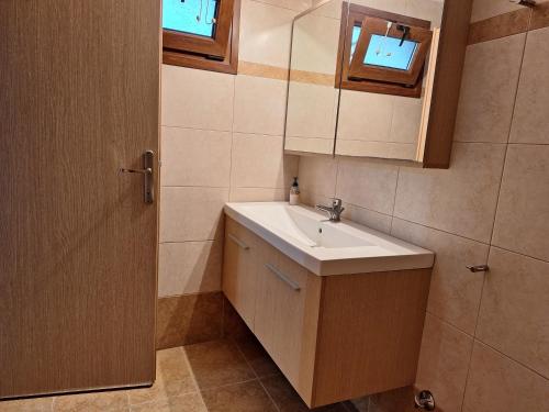 a bathroom with a sink and a mirror at Garden House KRISTI in Possidi