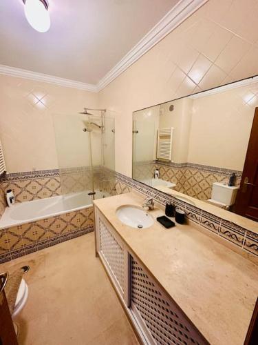a bathroom with a sink and a large mirror at Casa do Mar Cascais in Alcabideche