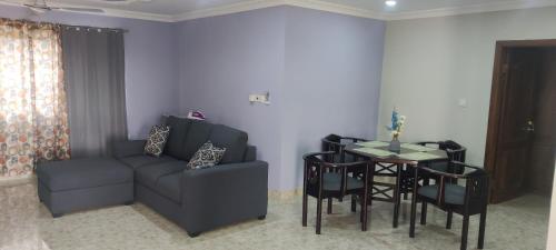 a living room with a couch and a table with chairs at Purple Springs Elmina #3 in Esamang