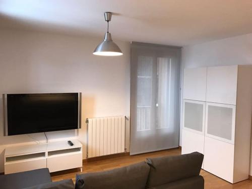 a living room with a couch and a flat screen tv at Apartamento la Abadía en Tramacastilla in Tramacastilla de Tena