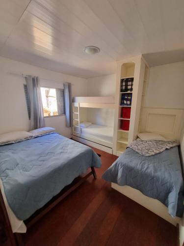 a bedroom with two beds and a window at Casa Maciel in São Thomé das Letras