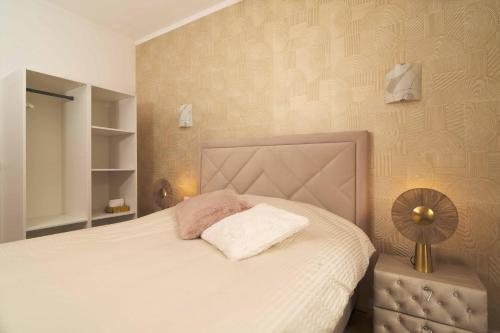 - une chambre avec un lit doté d'une couverture blanche et d'un ventilateur dans l'établissement Fourside Deluxe Apartments in Le Bourget, au Bourget