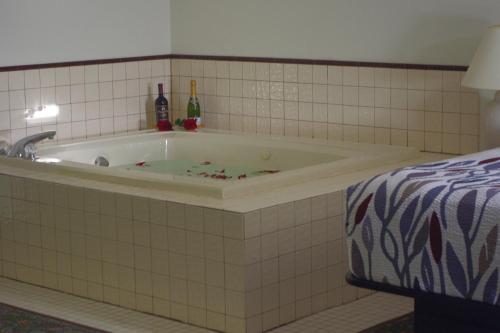 a bathroom with a bath tub with bottles on it at Selby Motel in Selby