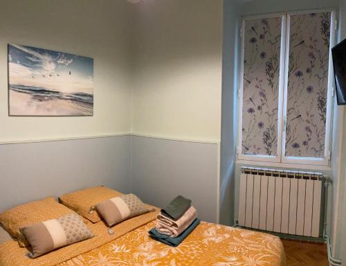 - une chambre avec un lit avec deux oreillers et une fenêtre dans l'établissement appartement cosy - 2 chambres, situé en Centre Ville, à Nice