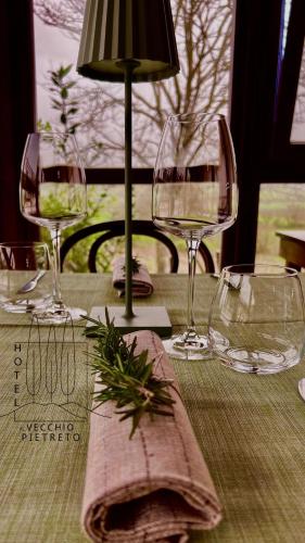 a table with wine glasses and a napkin on it at Hotel Il Pietreto in Colle Val D'Elsa