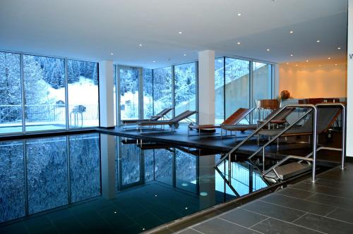 カップルにあるSchooren des Alpes Luxury Apartmentsのダイニングルーム(ガラスのテーブル、椅子付)