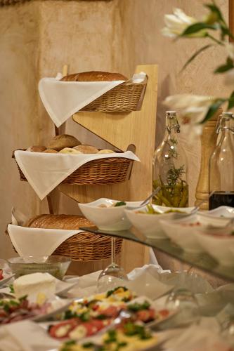 a table with plates of food and baskets of food at Baron Boutique Hotel in Jelenia Góra