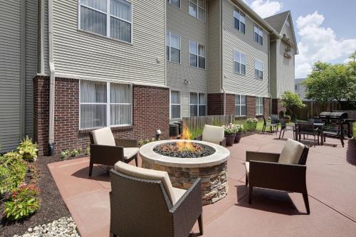 a patio with chairs and a fire pit in front of a building at Residence Inn Indianapolis Airport in Indianapolis