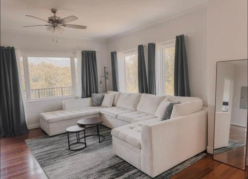 un soggiorno con divano bianco e ventilatore a soffitto di Modern Condo in the Smokies a Gatlinburg