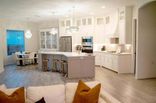 a large white kitchen with a couch and a table at Luxurious Gated 3BR Oasis No chore Pet friendly in Edinburg