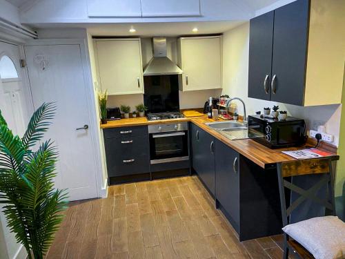 a kitchen with a sink and a stove top oven at Stylish Bungalow upto 6 guests in Caversham