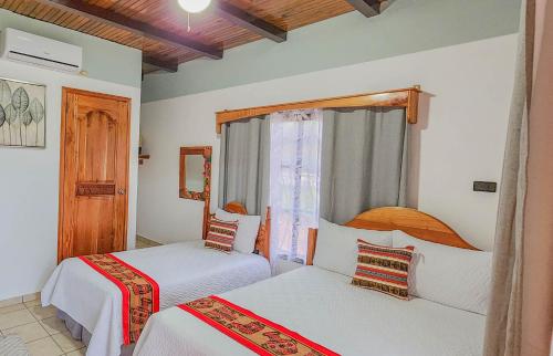 a bedroom with two beds and a window at Hotel Itzae in Copán Ruinas