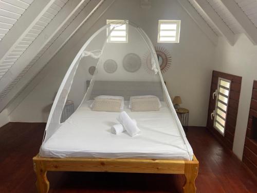 a bed with a canopy in a room at KaZa Bielle in Capesterre-de-Marie-Galante