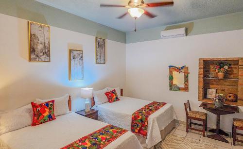 a bedroom with two beds and a ceiling fan at Hotel Itzae in Copán Ruinas