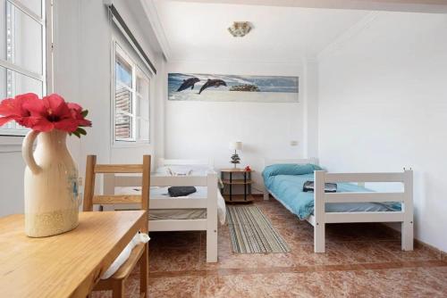 una camera con un letto e un tavolo con un vaso di Stunning 2-Bed House in Puerto de la Cruz a Puerto de la Cruz