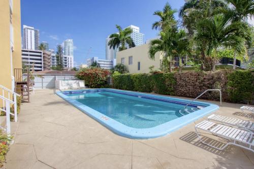 a swimming pool in a yard with chairs and trees at 23 Palms Suites - Midtown Wynwood in Miami