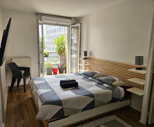 une chambre avec un lit et une grande fenêtre dans l'établissement Deux pièces spacieux - Métro ligne 14 à 50m, à Saint-Ouen