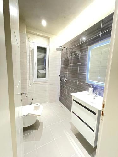 a white bathroom with a sink and a toilet at Apart-Hotel Suites - Qerret, Golem, Durres in Golem