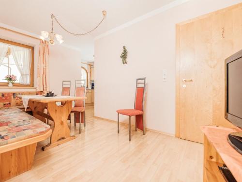 a living room with a table and a tv at Apart Christine in Aschau