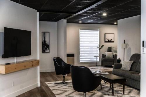 a living room with a flat screen tv and a couch at Downtown Campbellton Loft in Campbellton