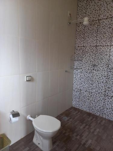 ein Badezimmer mit Toilette und Dusche in der Unterkunft Hospedaria Coração de Pedra in São Thomé das Letras