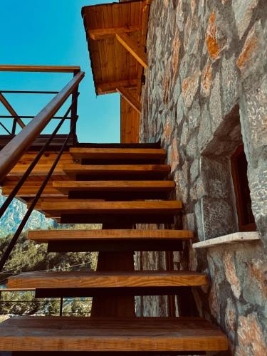 a set of wooden stairs next to a stone building at Vila Shkalla in Theth
