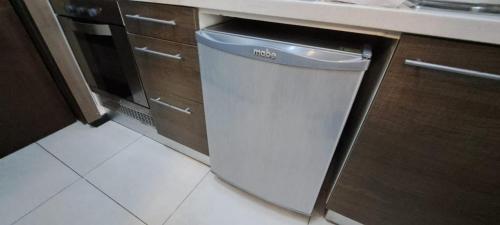 a white dishwasher in a kitchen next to a counter at Departamento frente Monumento Rosario in Rosario