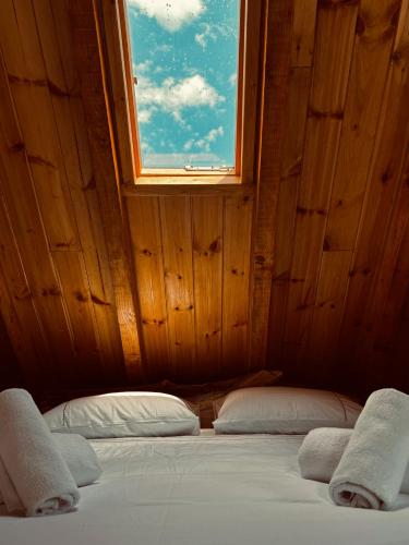 a bed with two pillows in a room with a window at Vila Shkalla in Theth