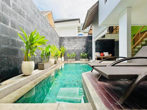 einen Pool in einem Haus mit Stühlen und Pflanzen in der Unterkunft The Loft Villas Echo in Canggu