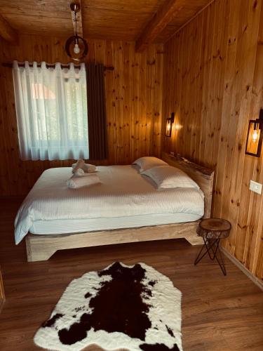 a bedroom with a bed in a room with wooden walls at Vila Shkalla in Theth