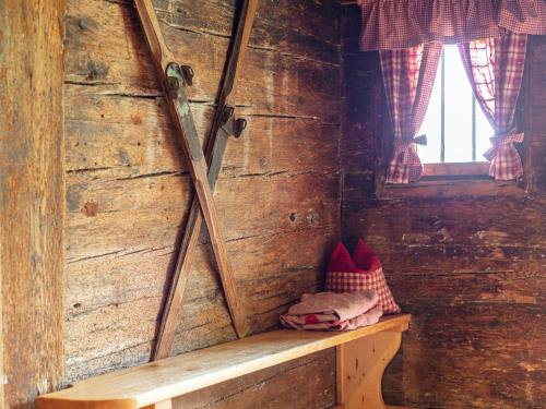a wooden wall with a bench in a room with a window at Alpin Hideaway XL in Bruggberg