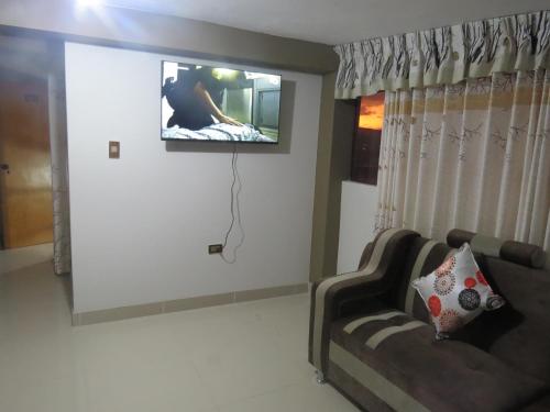 a living room with a couch and a tv on the wall at DEPARTAMENTO-Hospedaje EL RINCONCITO II 100m2, 3hab, 4baños, sala, comedor, cocina in Jauja