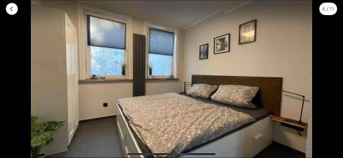 a bedroom with a bed and two windows at Ferienwohnung Schnezler in Hanerau-Hademarschen