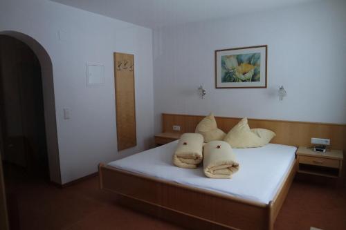 ein Schlafzimmer mit einem Bett mit zwei Kissen darauf in der Unterkunft Apart Alina in Galtür