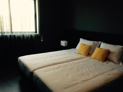 a bedroom with a large bed with two yellow pillows at Figurino do Douro in Melres