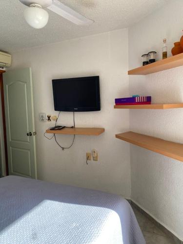 a bedroom with a bed and a flat screen tv at Ocean Front - Ground Floor Condo in Cancún