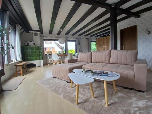 a living room with a couch and a table at Ferienwohnung Lodge am See - Terrasse - Kachelofen in ruhiger Lage nahe Schluchsee in Schluchsee