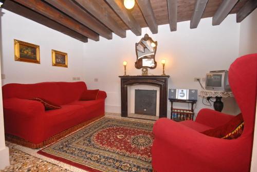 a living room with red couches and a fireplace at Appartmento Ca' Rio Marin in Venice