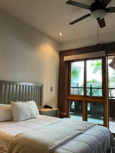 a bedroom with a bed and a ceiling fan at Hotel Casa Carmona in Querétaro