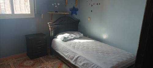ein kleines Schlafzimmer mit einem Bett und einem Nachttisch in der Unterkunft Appartement à louer pour famille et couple marié in Mohammedia
