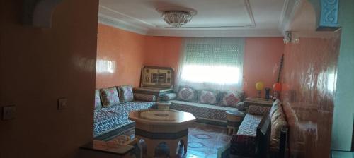 ein Wohnzimmer mit einer Couch und einem Fenster in der Unterkunft Appartement à louer pour famille et couple marié in Mohammedia