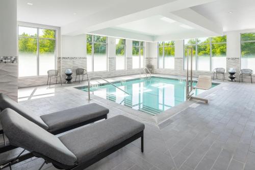 a swimming pool with a couch and a chair at Residence Inn by Marriott Boston Concord in Concord