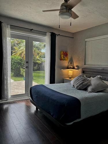 a bedroom with a bed and a large window at Pool House Resort heated swimming pool private duplex in Cutler Bay